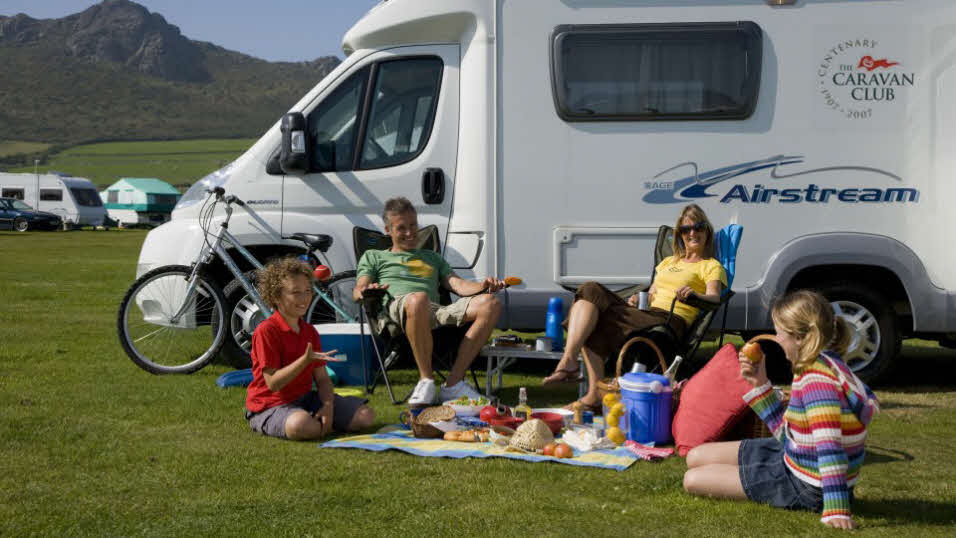 Family sitting by a caravan